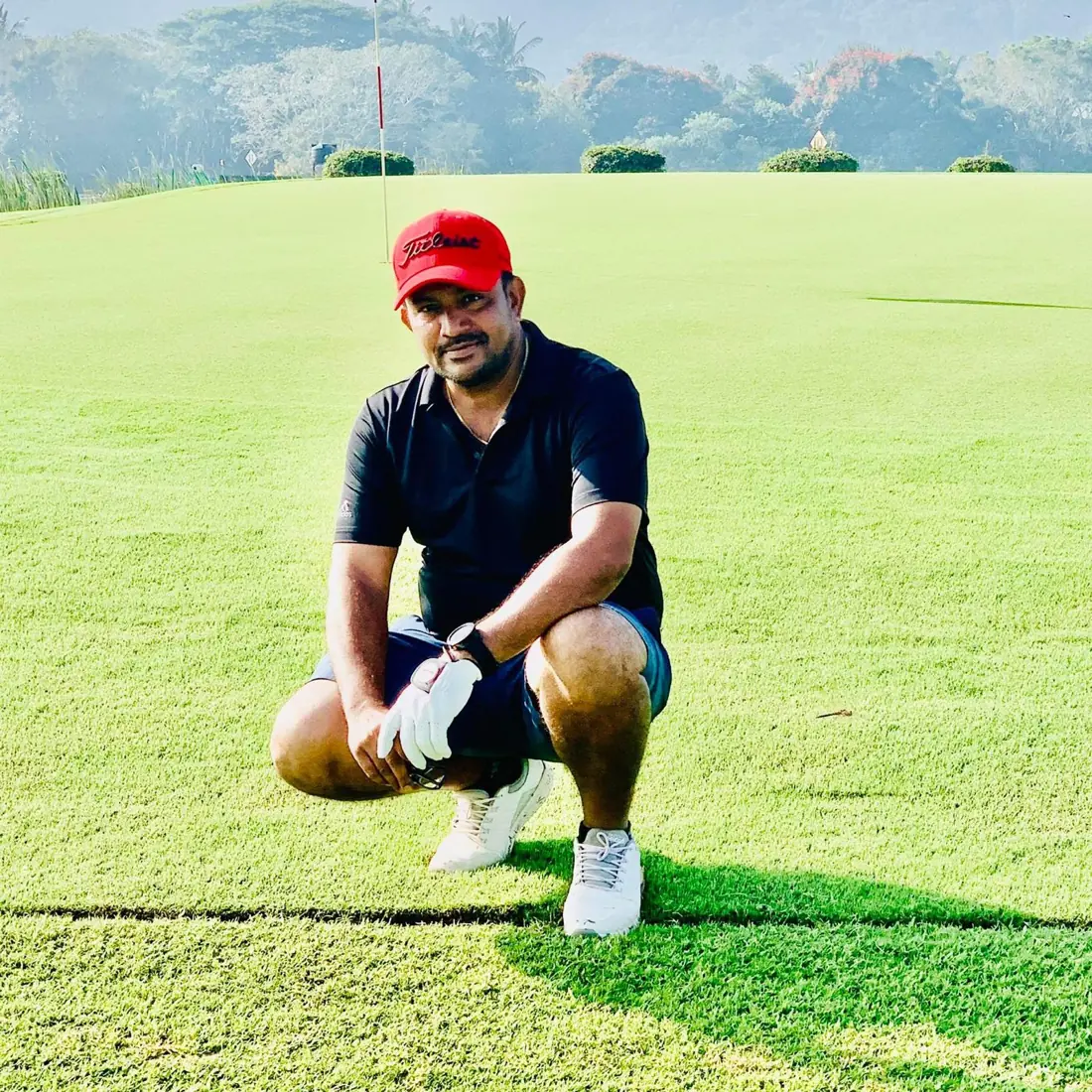 Mysuru Tigers golfer kneeling on the green beside the pin at JWGC